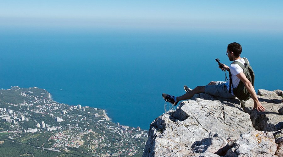 A tourist is photographed on top of the Ai-Petri mountain in Crimea