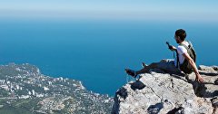 A tourist is photographed on top of the Ai-Petri mountain in Crimea